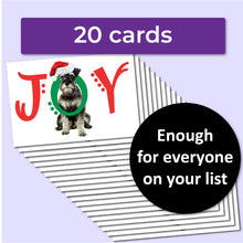 Load image into Gallery viewer, A white Christmas card with a schnauzer dog on the front with the word JOY. The J and Y are red, and the O is green and wrapped around the dog&#39;s neck. 20 cards come in the pack, enough for everyone on your list.
